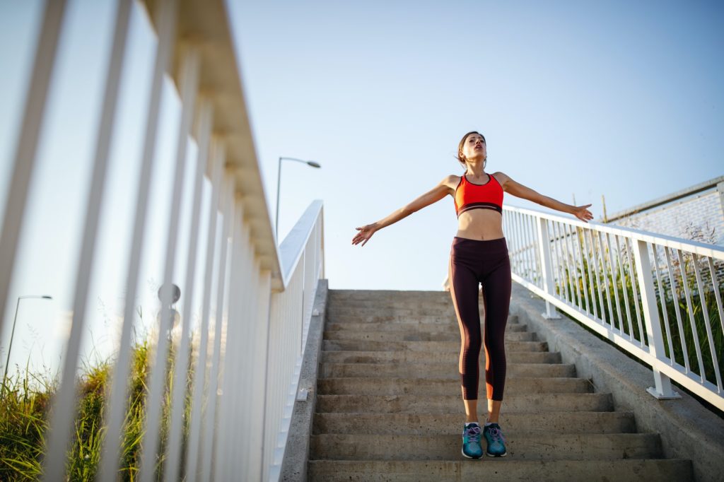 Happy young woman exercising outdoors. Living healthy life